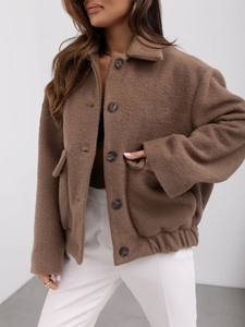 Détails de la texture du tissu en laine marron et de la fermeture à boutons de la veste
