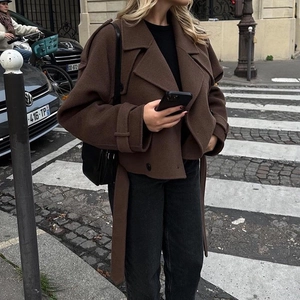 Women's short brown wool coat with large lapels and waist belt in street style fashion