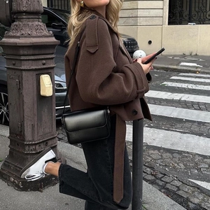 Manteau court marron en laine à revers avec ceinture dans un cadre urbain élégant
