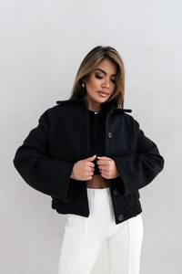 Détail d'une veste courte noire à boutonnage avec revers et coupe décontractée chic