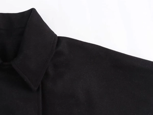Detail view of the lapel and stitching on the black wool blend oversized jacket
