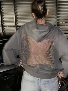 Detailansicht der glitzernden silbernen Strass-Applikation am Rücken des grauen Hoodies