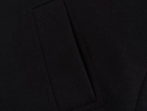 Close-up of the precise stitching and pocket detail on a black wool jacket
