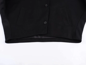 Close-up detail of black wool jacket featuring resin buttons and symmetrical side pockets