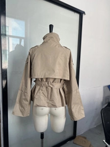 Détail du dos d'un trench court kaki avec bavolet et ceinture nouée à la taille