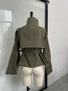 Detail view of military green cropped trench coat with storm flap and fabric waist belt