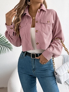 Detail van roze corduroy jas met geribbelde textuur, klepzakken en knoopsluiting