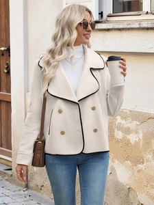 Detail of beige short wool coat featuring double-breasted buttons and black piping trim