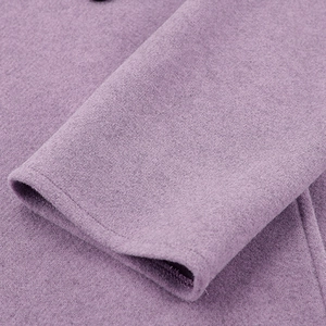 Detail van de lavendelkleurige wollen jas mouw met fijne textuur en netjes stikwerk