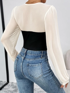 Rear view of slim fit bodysuit showing white mesh sleeves and black ribbed knit texture