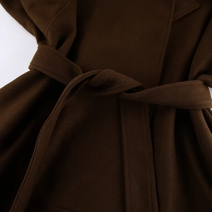 Detalle de abrigo de lana marrón oscuro con textura gruesa y cinturón de lazo en la cintura