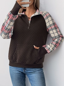 Detail of quilted brown pullover with 1/4 zipper collar and pink plaid patchwork sleeves