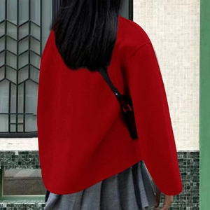 Detailweergave van rode wollen jas met dubbele knopen in casual britse stijl