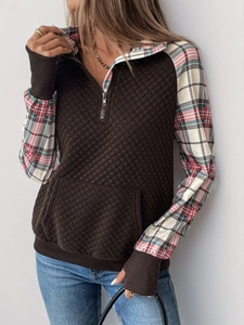 Detail of brown quilted sweatshirt with plaid lining and metal half-zipper collar