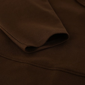 Primer plano de la manga del abrigo de lana marrón oscuro con textura suave y costura