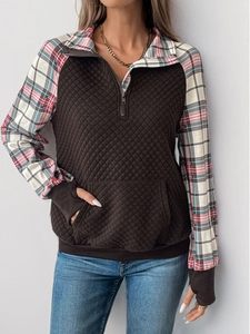 Detail view of brown quilted texture fabric and retro plaid patchwork on long sleeve pullover