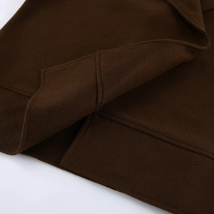 Primer plano de la tela del abrigo de lana marrón con textura premium y costuras finas