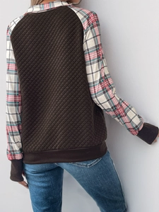 Detail of vintage patchwork sweatshirt featuring brown quilted body and plaid sleeves