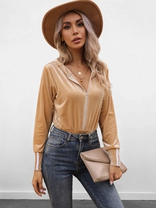 Close-up of beige velvet hooded bodysuit featuring long sleeves with white stripe accents