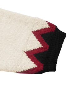 Détail de la manchette d'un pull en tricot avec motifs jacquard et texture côtelée