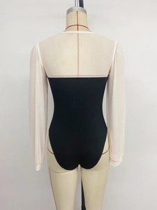 Detail of black ribbed knit body and white sheer sleeve contrast stitching on bodysuit
