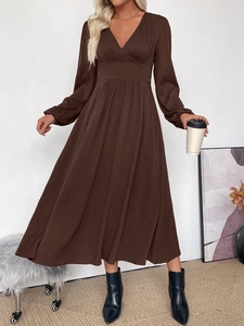 Close-up of elegant V-neckline and high waist pleated details on a brown midi dress