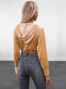 Detail view of a slim-fit velvet hooded bodysuit and high-waist jeans from the back side