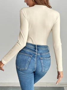 Détail du body en maille côtelée beige vu de dos montrant la coupe ajustée du vêtement