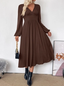 Detail of V-neckline and pleated waist on this brown long sleeve midi dress