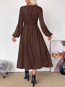 Detail of V-neck brown midi dress with high elastic waist and lantern sleeve silhouette