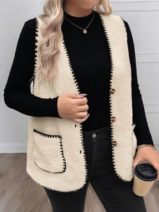 Detail der beige Fleeceweste mit schwarzen Ziernähten und Schildpattknöpfen