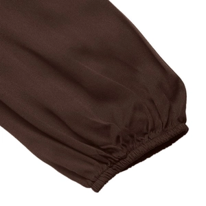 Close-up of the elastic ruffled cuffs on a brown long-sleeved French commute dress