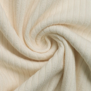 Vue macro détaillée du tissu en maille côtelée crème avec texture douce et élasticité