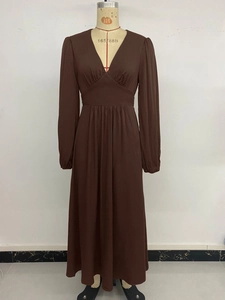 Detail view of the V-neckline and high-waist pleated design on the brown maxi dress