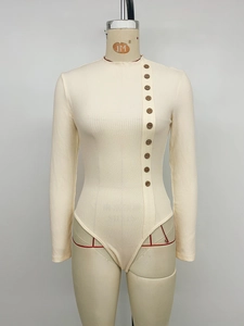 Détail d'un body en maille côtelée beige avec boutons décoratifs latéraux effet bois