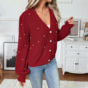 Red V-neck knit cardigan with pearl beads and floral buttons over blue jeans