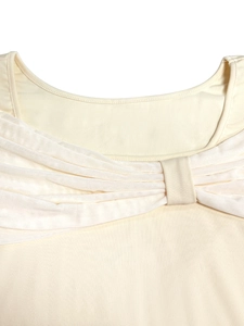 Close-up of cream knit top with mesh bow detail and elegant pleated U-neckline