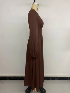 Detail of a brown long-sleeved French V-neck dress with cinched waist and maxi length