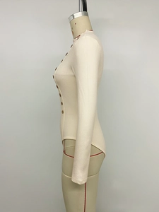 Détail d'un body en maille côtelée beige avec des boutons décoratifs marron sur le devant