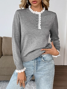 Detail of grey knit sweater featuring elegant white lace trim and buttoned neckline