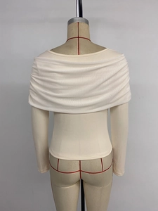 Rear view of off-shoulder beige knit top featuring a large twisted shawl collar design