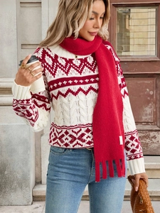 Detail of red and white jacquard sweater paired with a red tassel scarf and woven bag
