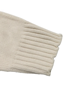 Close-up of ribbed cuffs on cream-white knit sweater showing detailed texture