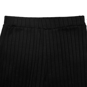 Detailed macro view of the wide elastic waistband on black ribbed knit texture trousers