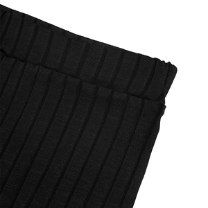 Detailed macro view of the black ribbed fabric texture and elastic waistband of the set