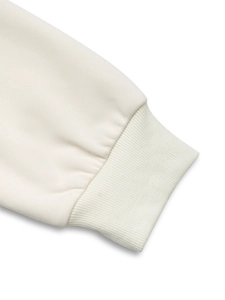 Detailed close-up of soft cream-colored ribbed cuffs on a cotton sweatshirt sleeve