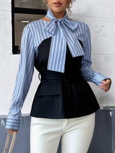 Close-up of elegant striped shirt with bow tie and black waist-cinching vest detail