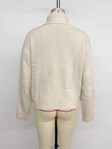 Detail of the back view of a beige high-neck knit sweater with chunky ribbed texture