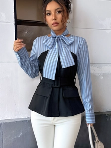 Detail of elegant blue striped shirt with black vest overlay and matching belt