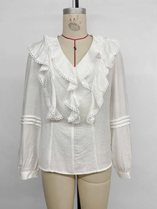Detail of the V-neckline featuring layered ruffle trim and delicate lace on a white shirt
